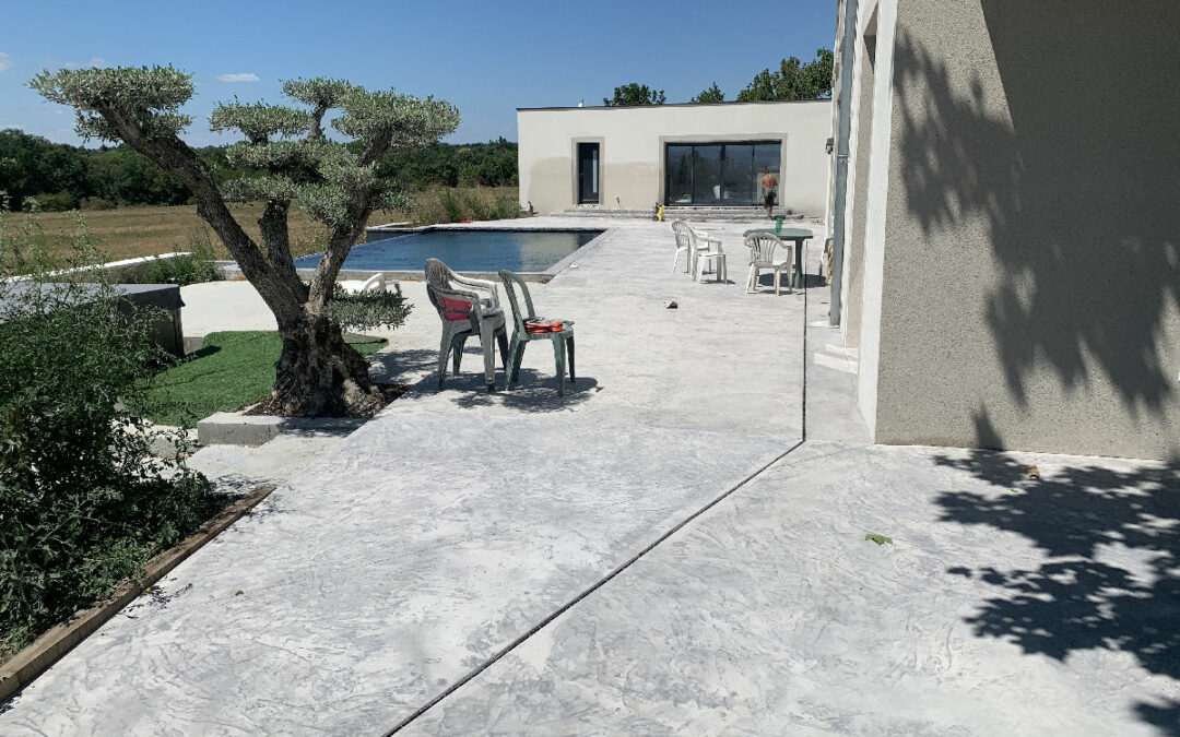 Dardilly, piscine à débordement, terrasse béton imprimé et terrasse bois