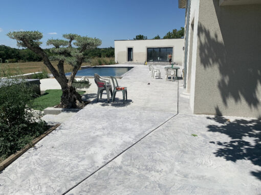 Dardilly, piscine à débordement, terrasse béton imprimé et terrasse bois