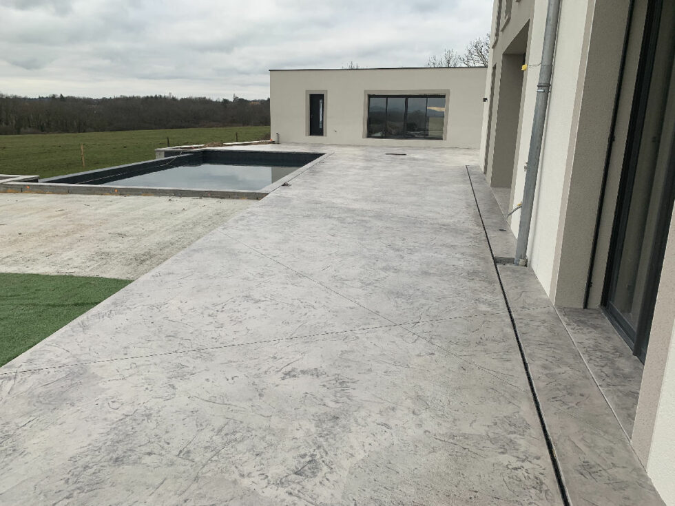 terrasse en béton imprimé devant baie vitrée à Dardilly